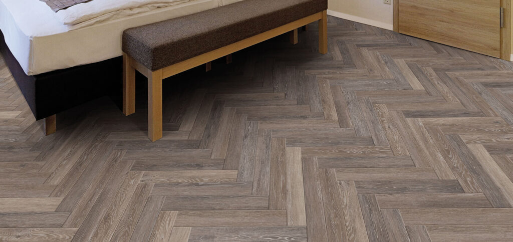 Visgraat PVC vloer in vintage stijl met natuurlijke houtlook en gedempt kleurenpatroon