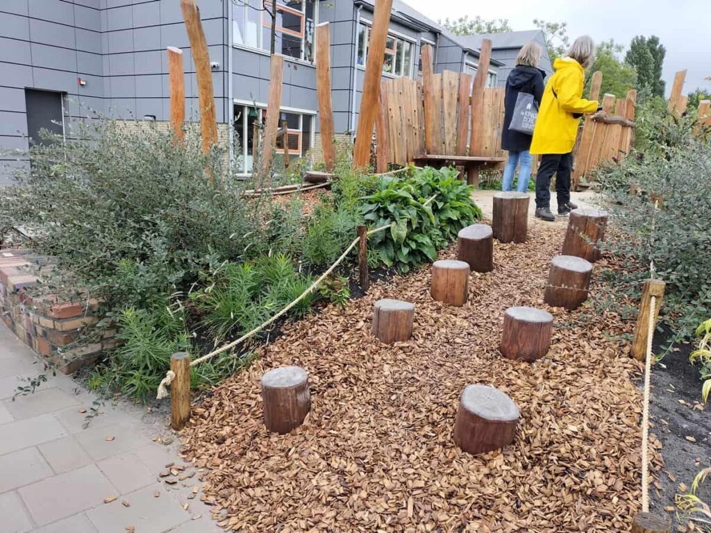 Inrichting groen en blauw schoolplein met beplanting, waterpartijen en natuurlijke speelelementen voor kinderontwikkeling
