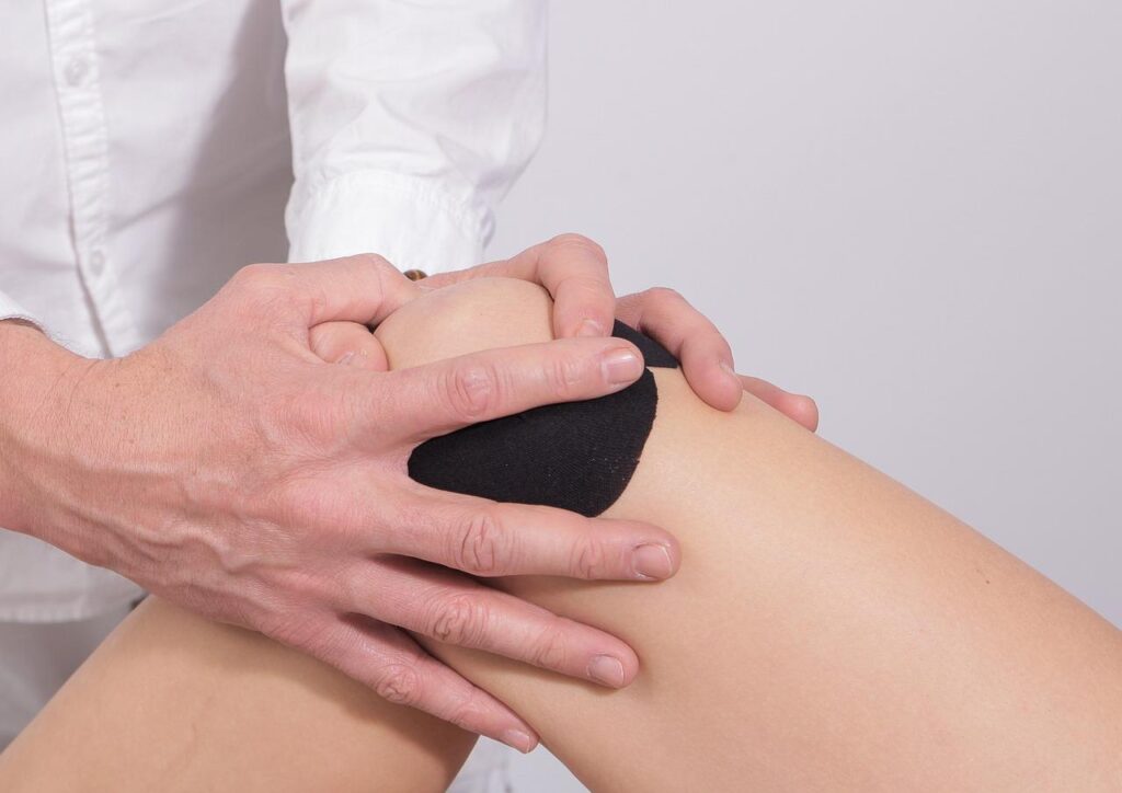 Fysiotherapeut begeleidt patiënt bij revalidatie na een nieuwe knie met mobilisatie oefeningen