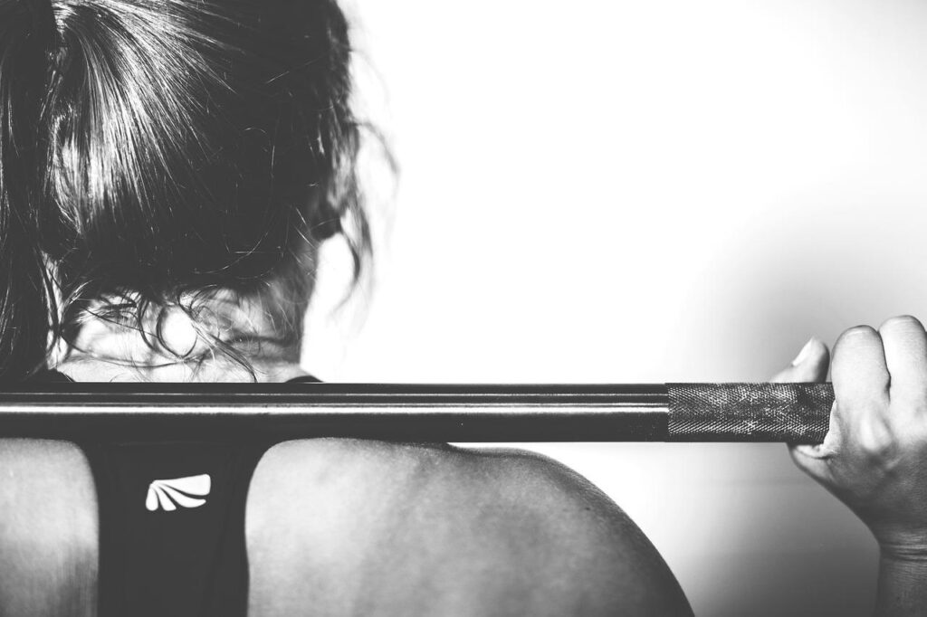 Sportschool Almere faciliteit met moderne fitnessapparatuur en leden die trainen onder begeleiding van gecertificeerde traine